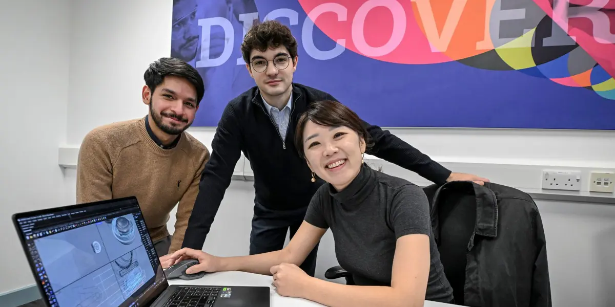 Lucy Jung (front right), a Cambridge NeuroWorks Fellow, sitting at a desk with two of her team members