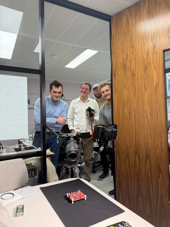 The Normal Computing team doing a photoshoot of their thermodynamic computing chip.