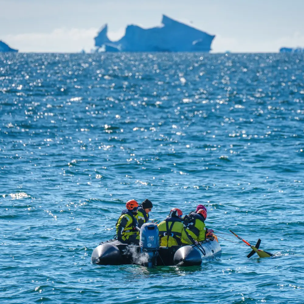 A team of scientists and crew members deploy an underwater glider in Antarctica.
